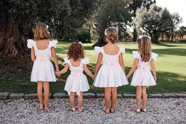 Quatres petites filles de dos habillées en vêtements de cérémonie maison ème