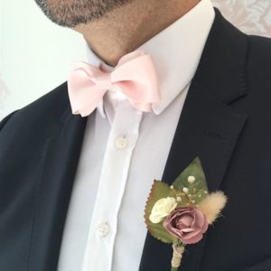 Futur marié avec une boutonnière fleurie sur veste de costume
